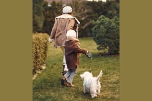 Бишон фризе гуляет с хозяевами