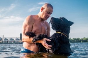 Гигантский шнауцер купается с хозяином
